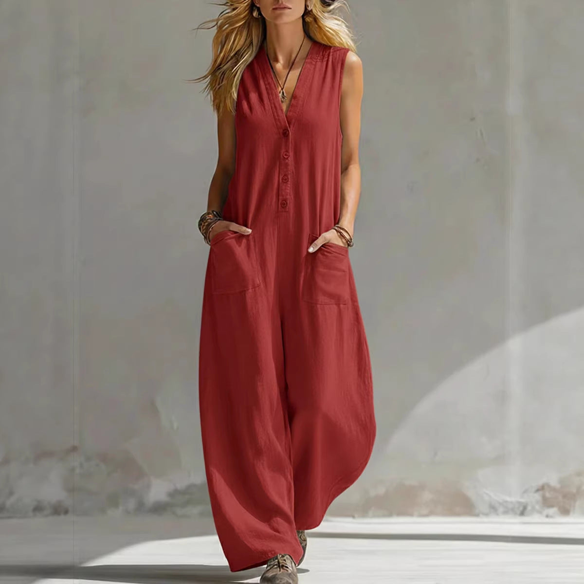 Woman wearing a red sleeveless jumpsuit against a neutral background