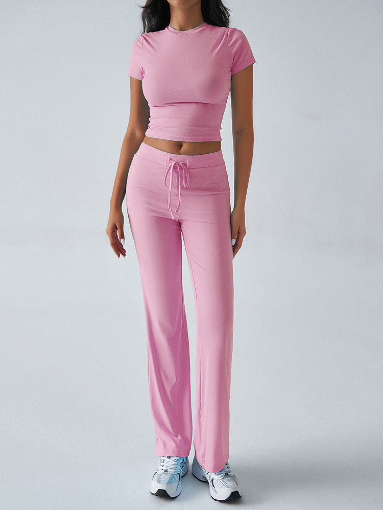 Person wearing a pink outfit with a matching top and pants on a white background