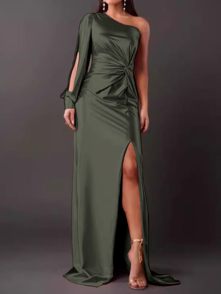 Woman wearing a green one-shoulder dress with a slit on a dark background