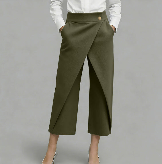 Green wide-leg pants worn with a white shirt on a gray background