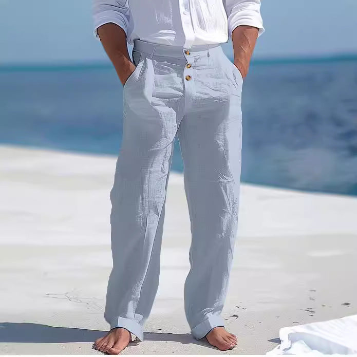 Person wearing light gray pants with a blurred beach background