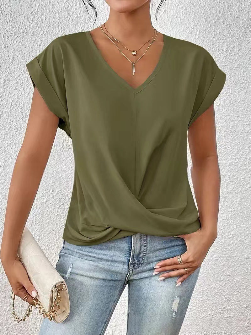 Person wearing an olive green top and blue jeans against a white background