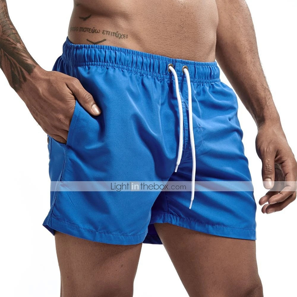 Blue swim shorts with a white drawstring on a neutral background
