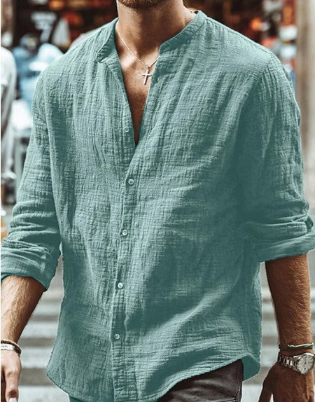Man wearing a green linen shirt with rolled-up sleeves in an urban setting
