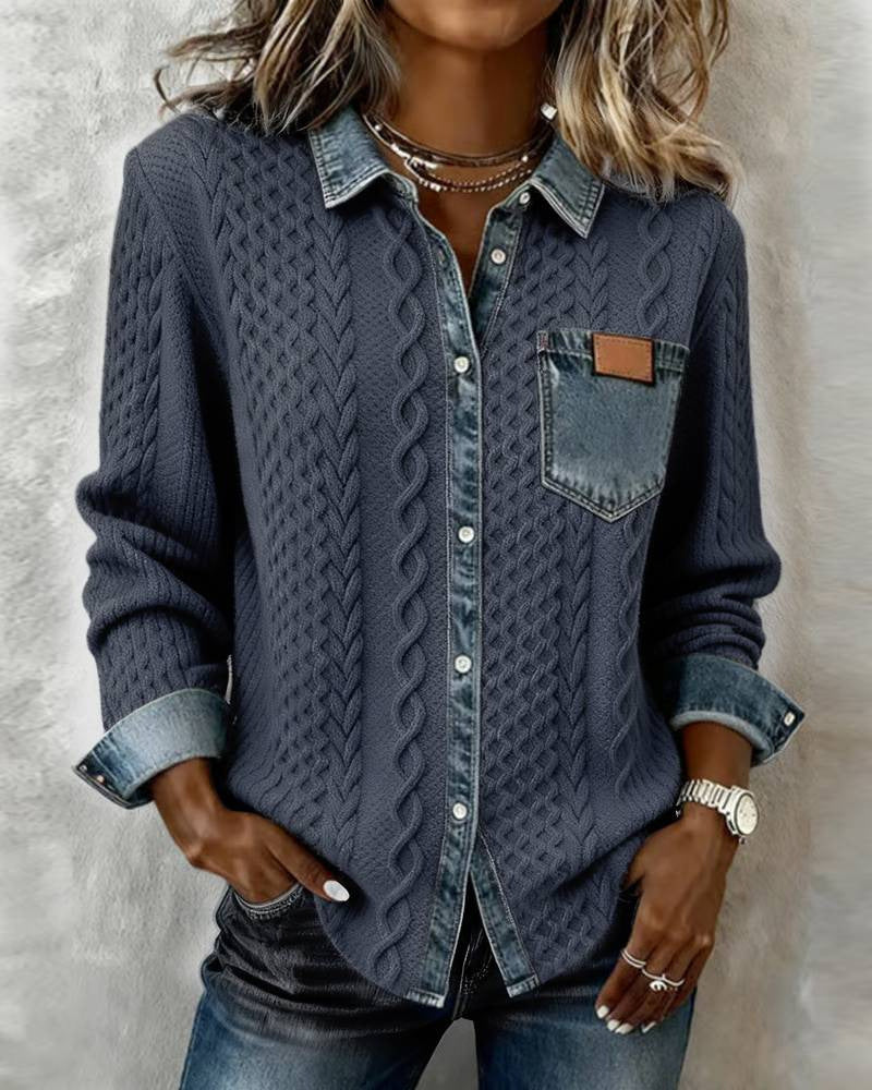 Person wearing a blue textured shirt with rolled-up sleeves on a neutral background