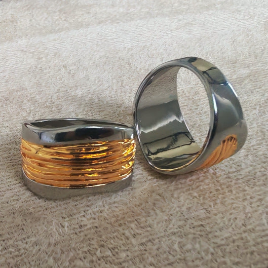 Two silver rings with textured design on a beige surface