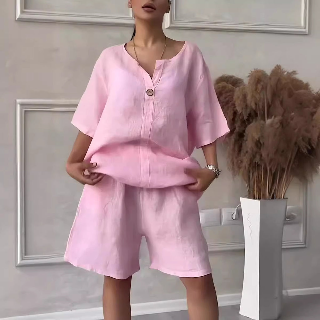 Person wearing a pink outfit standing in a room with decorative elements.