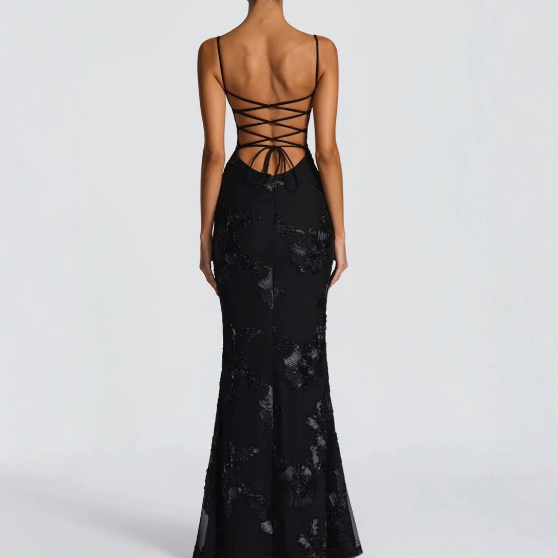 Black lace evening gown with intricate back design on a white background