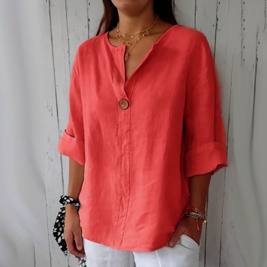 Person wearing a coral pink shirt with a neutral background