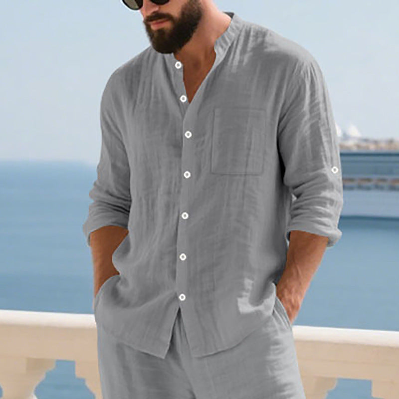 Man wearing a gray shirt and pants with a blurred coastal background