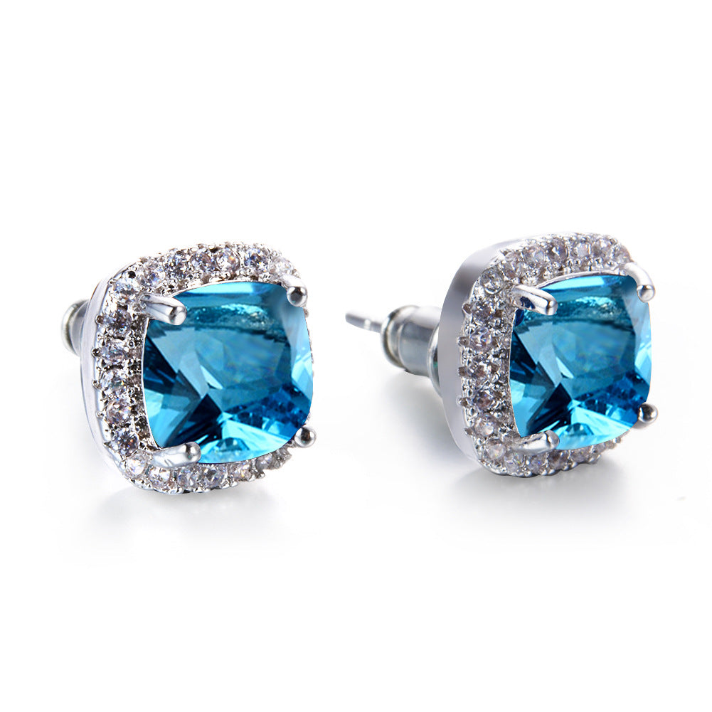 Pair of blue gemstone earrings with silver accents on a white background