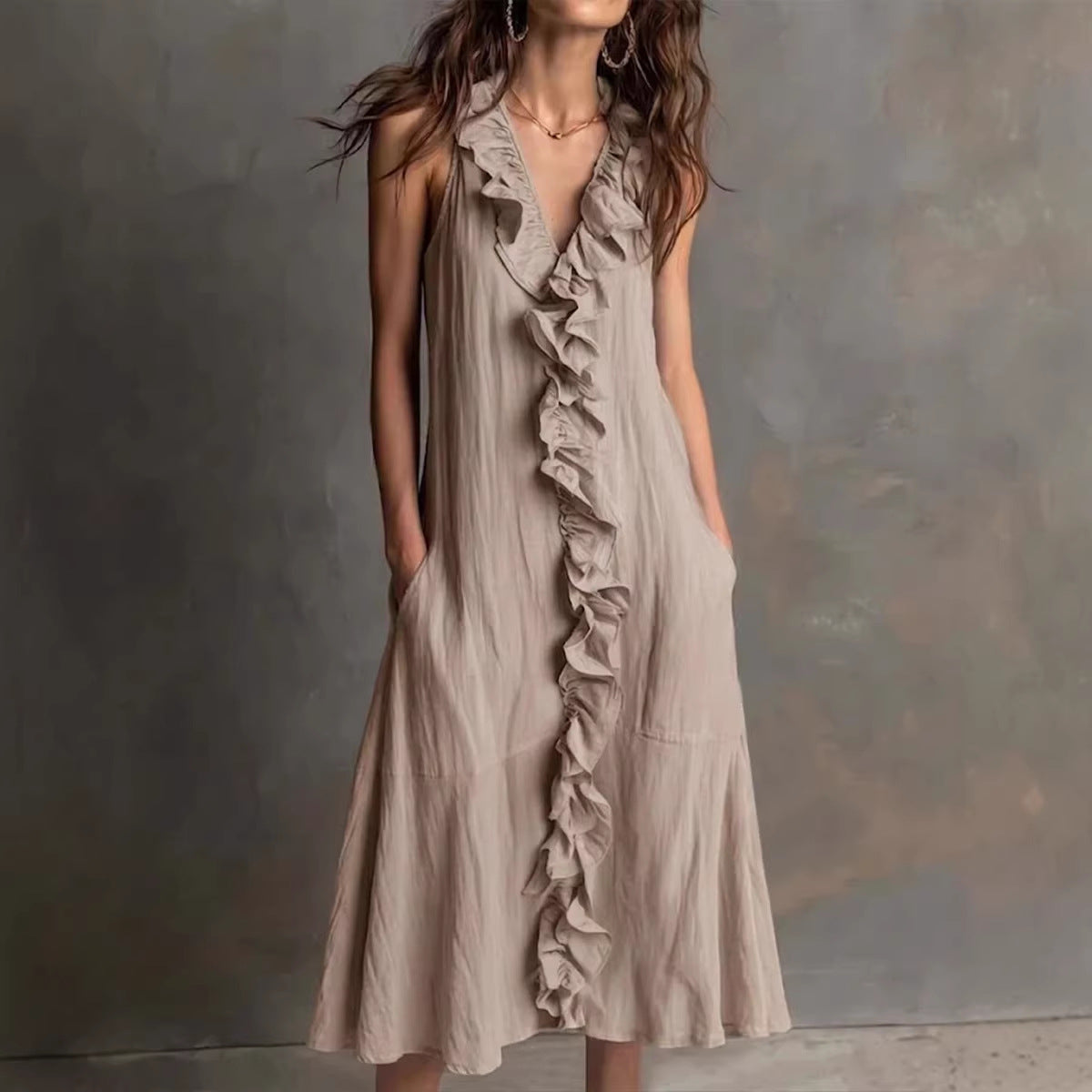 Woman wearing a beige ruffled dress against a gray background
