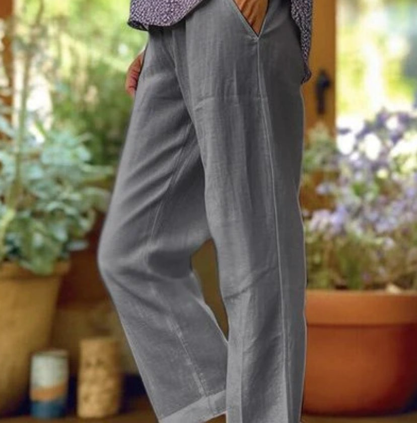 Gray pants worn by a person with a blurred garden background