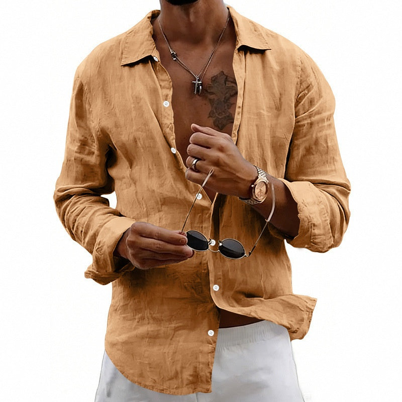 Man wearing a tan shirt holding sunglasses on a white background