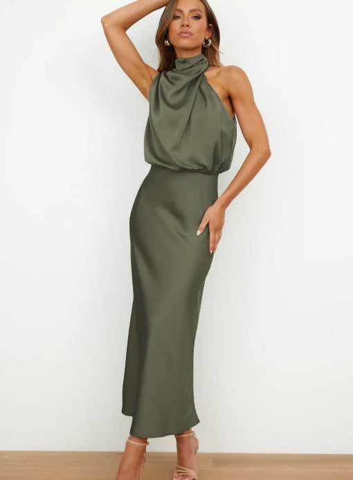 Woman wearing a green halter neck dress against a white background