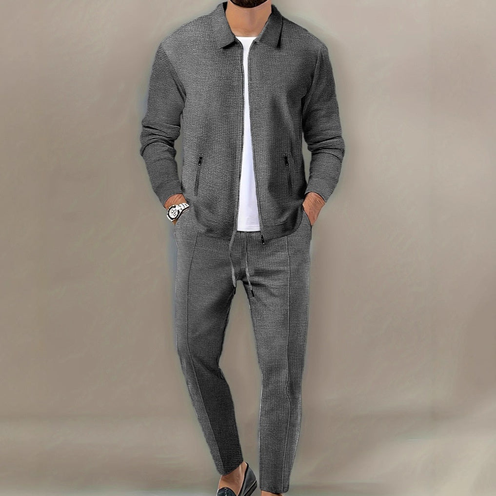 Person wearing a gray checkered outfit with a plain background