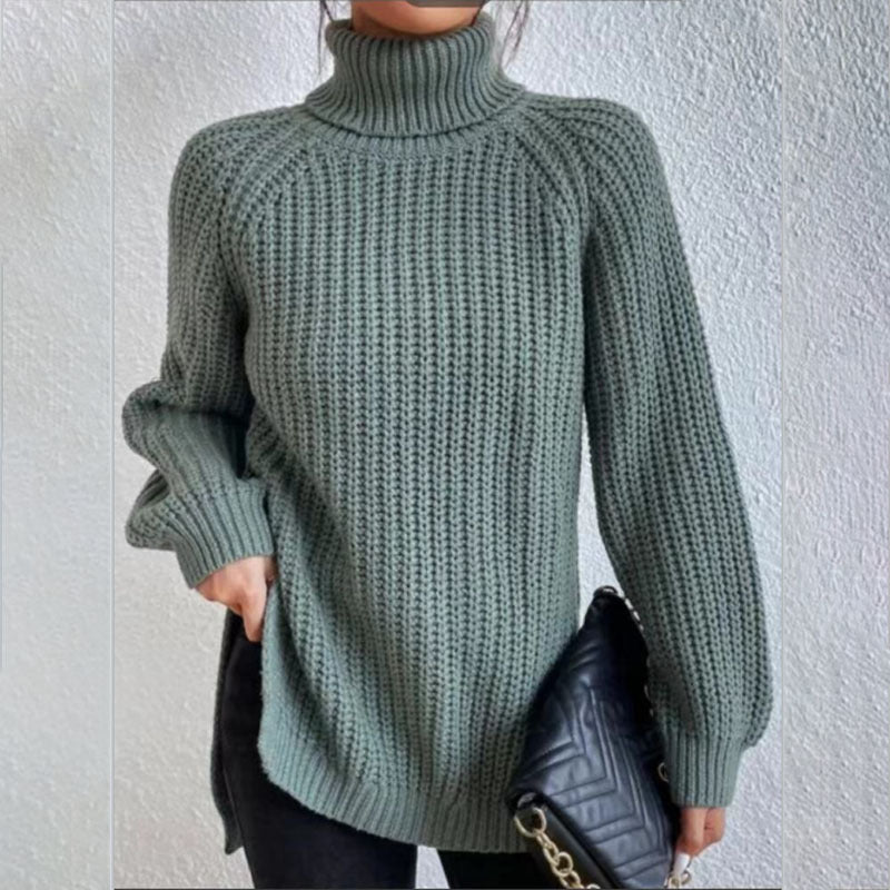 Person wearing a green knitted sweater against a white wall