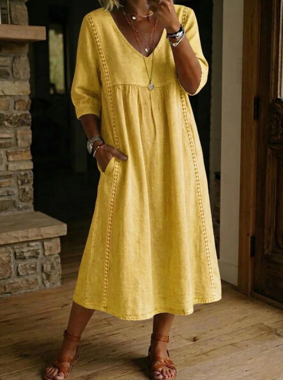 Woman wearing a yellow dress standing indoors.