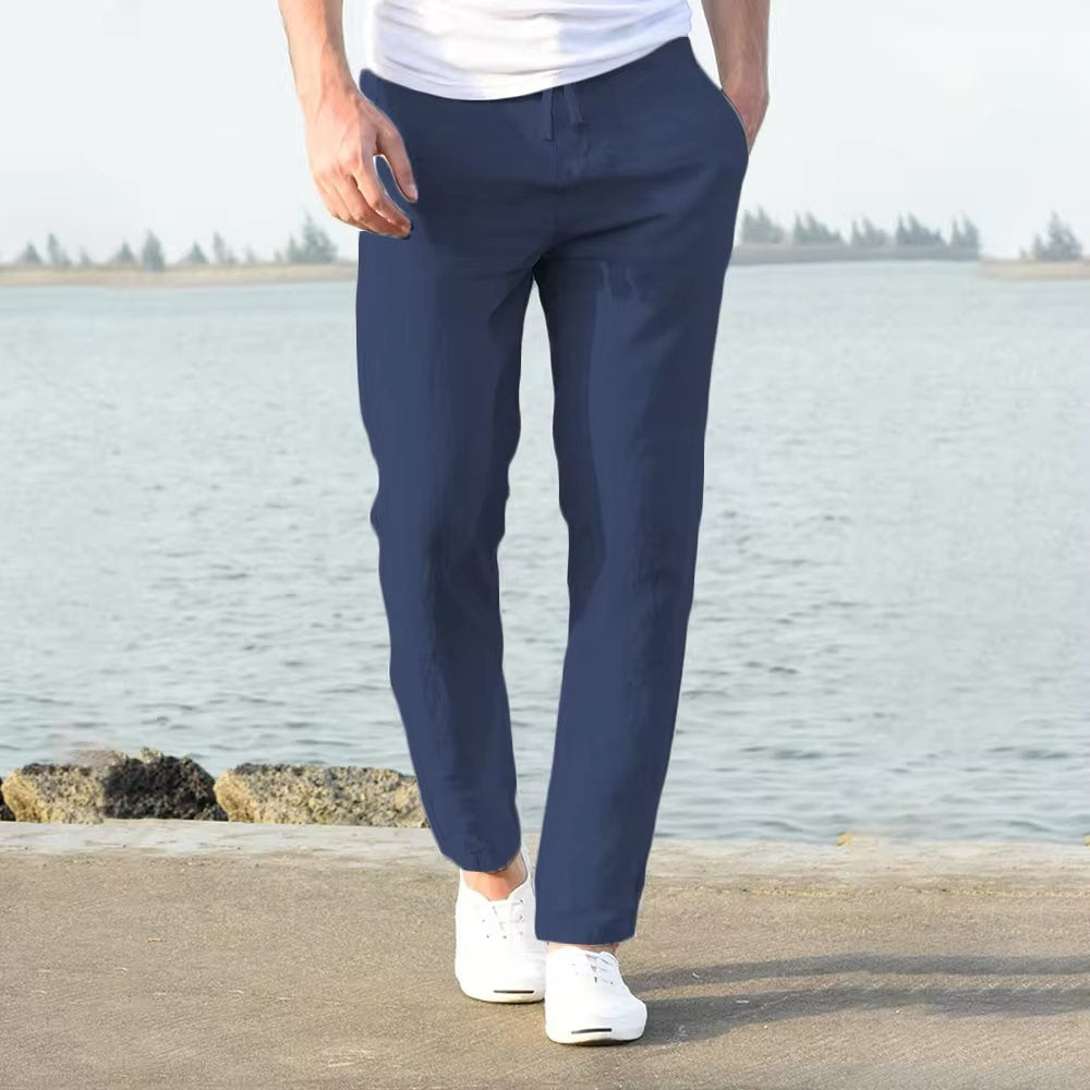 Person wearing navy pants standing by a body of water