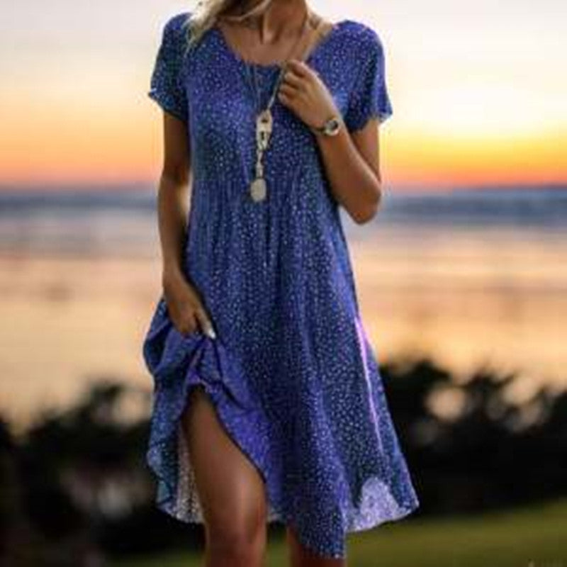 Woman wearing a blue dress with a sunset and beach in the background