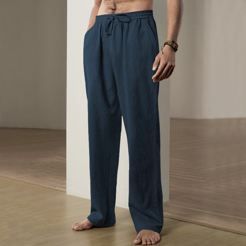 Person wearing navy blue pants standing against a neutral background