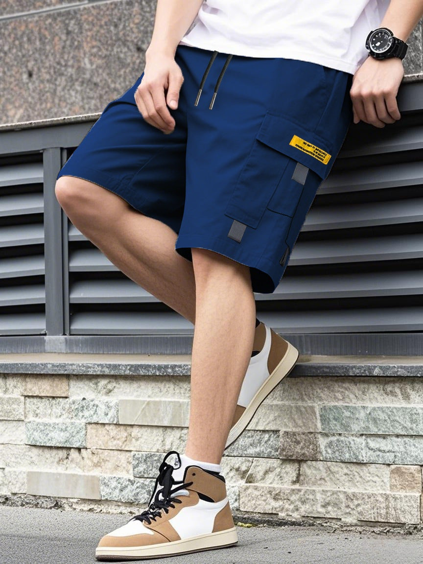 Person wearing blue cargo shorts with a yellow label, sitting on steps.