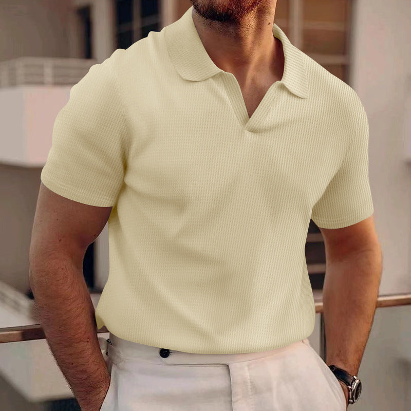 Man wearing a light yellow polo shirt in an indoor setting