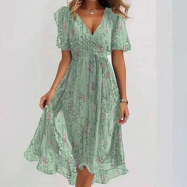 Green floral dress worn by a model on a light gray background