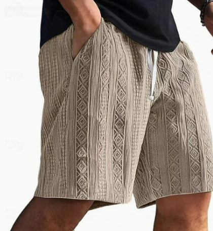 Beige patterned shorts worn by a person on a white background