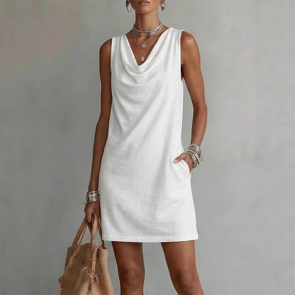 Woman wearing a white sleeveless dress against a plain background