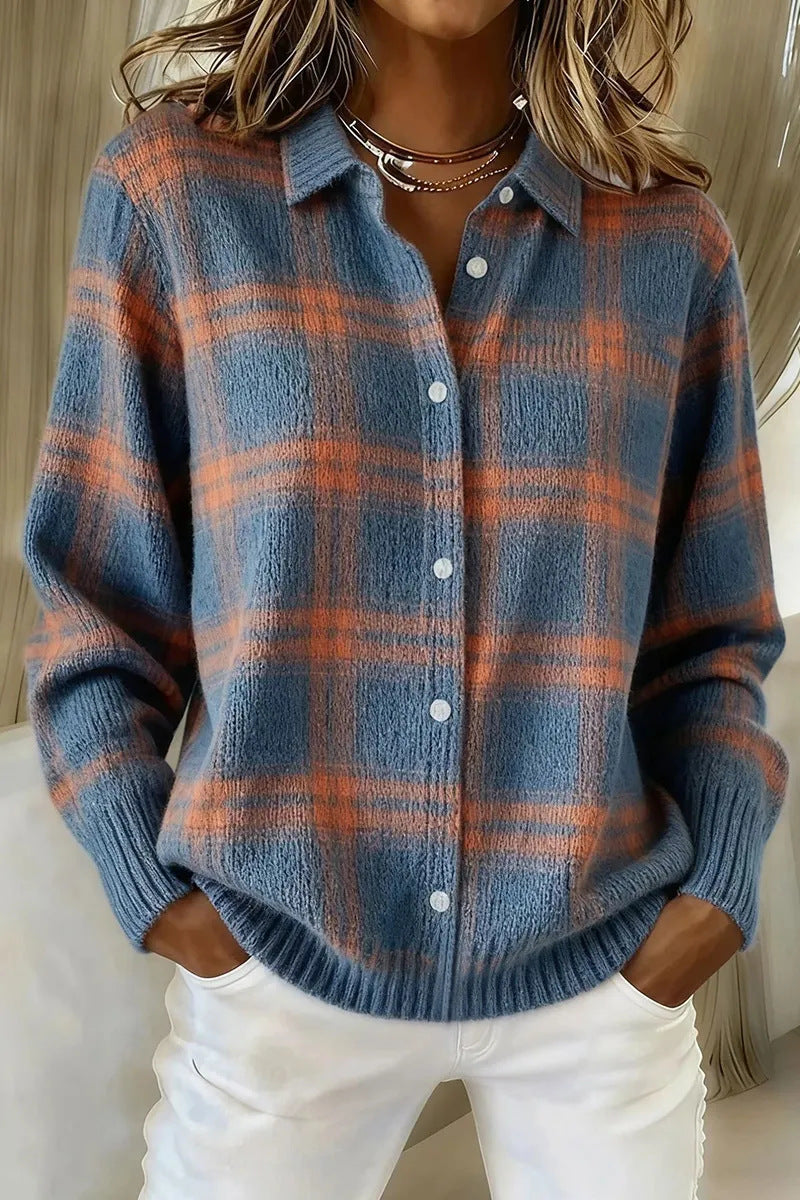 Person wearing a blue and orange plaid shirt with white pants indoors.