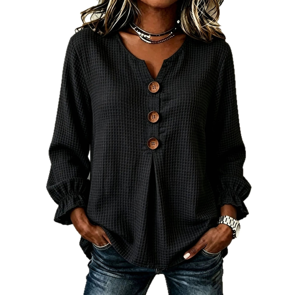 A woman wearing a black waffle-textured long-sleeve blouse with a split V-neck and three brown buttons down the front, paired with blue jeans.