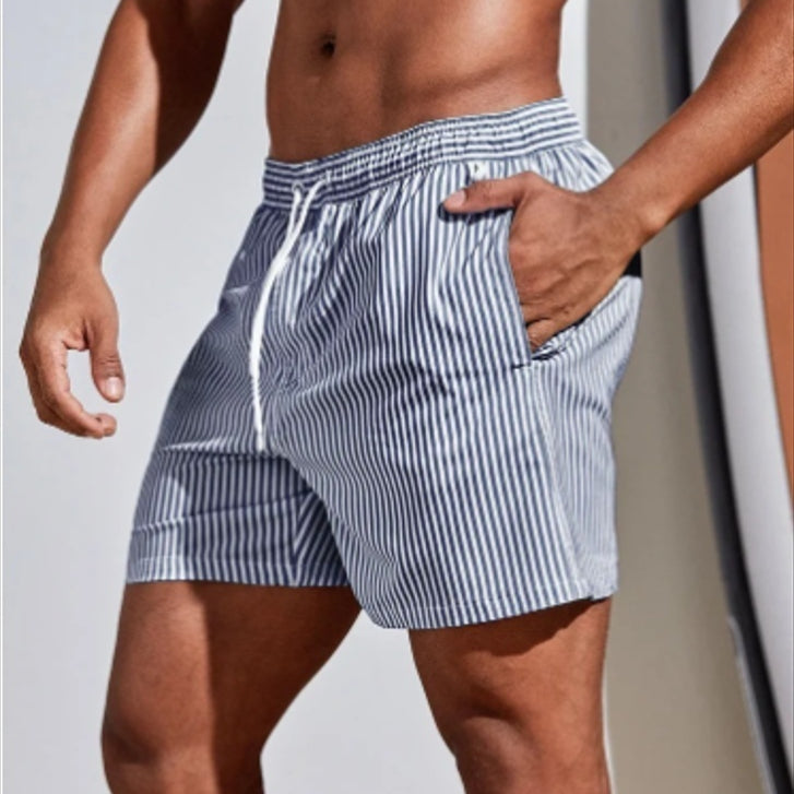 Person wearing blue and white striped swim shorts against a neutral background