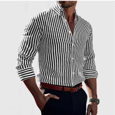 Man wearing a black and white striped shirt with rolled-up sleeves on a plain background