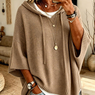 Person wearing a beige sweater in a cozy indoor setting