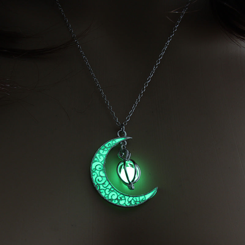 Glowing green moon-shaped pendant necklace on a dark background