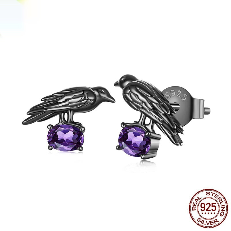 Black bird-shaped earrings with purple gemstones on a white background, featuring '925 Sterling Silver' stamp.