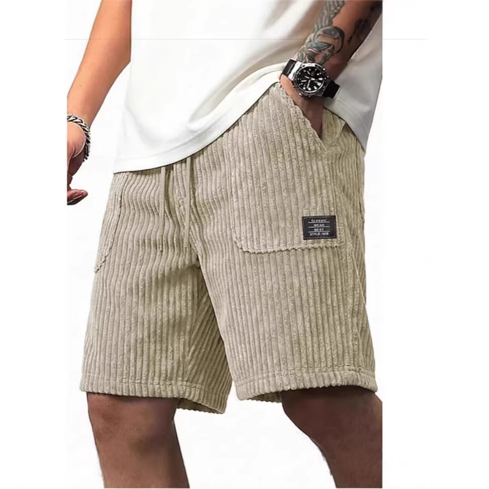 Beige corduroy shorts worn by a person on a white background