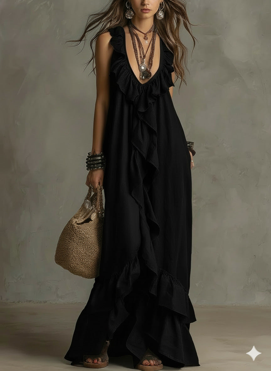 Woman wearing a black dress with ruffles, holding a woven bag against a neutral background