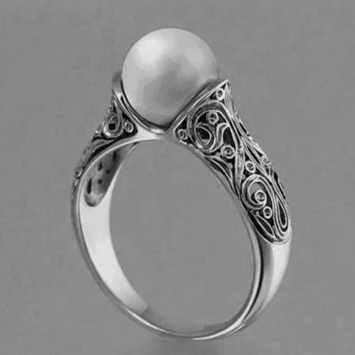 Silver ring with a pearl on a gray background