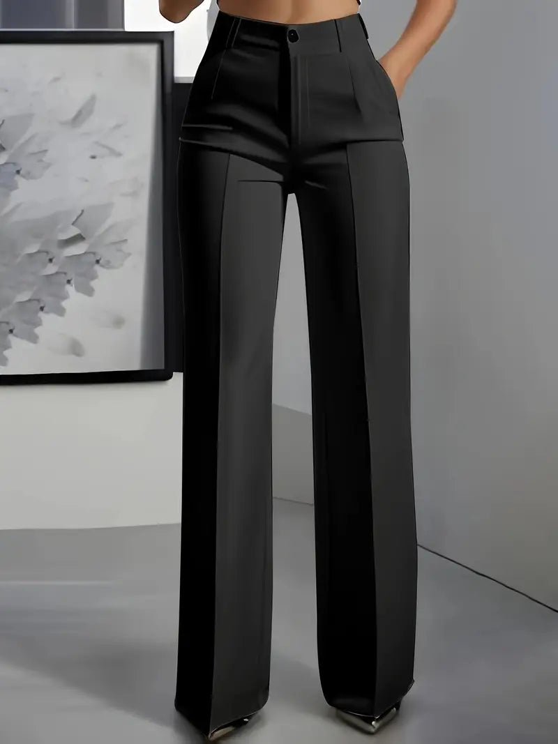 Black wide-leg pants worn by a person in a minimalistic setting with a gray wall and framed abstract art.