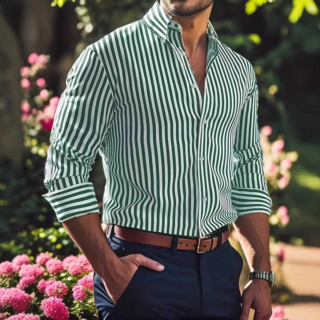 Man wearing a green and white striped shirt with rolled-up sleeves, standing outdoors with flowers in the background.