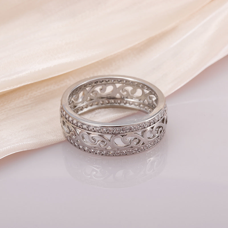 Silver ring with intricate design on a light background