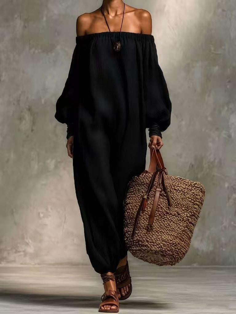 Person wearing a black off-shoulder top and high-waisted pants, holding a woven bag against a neutral background.