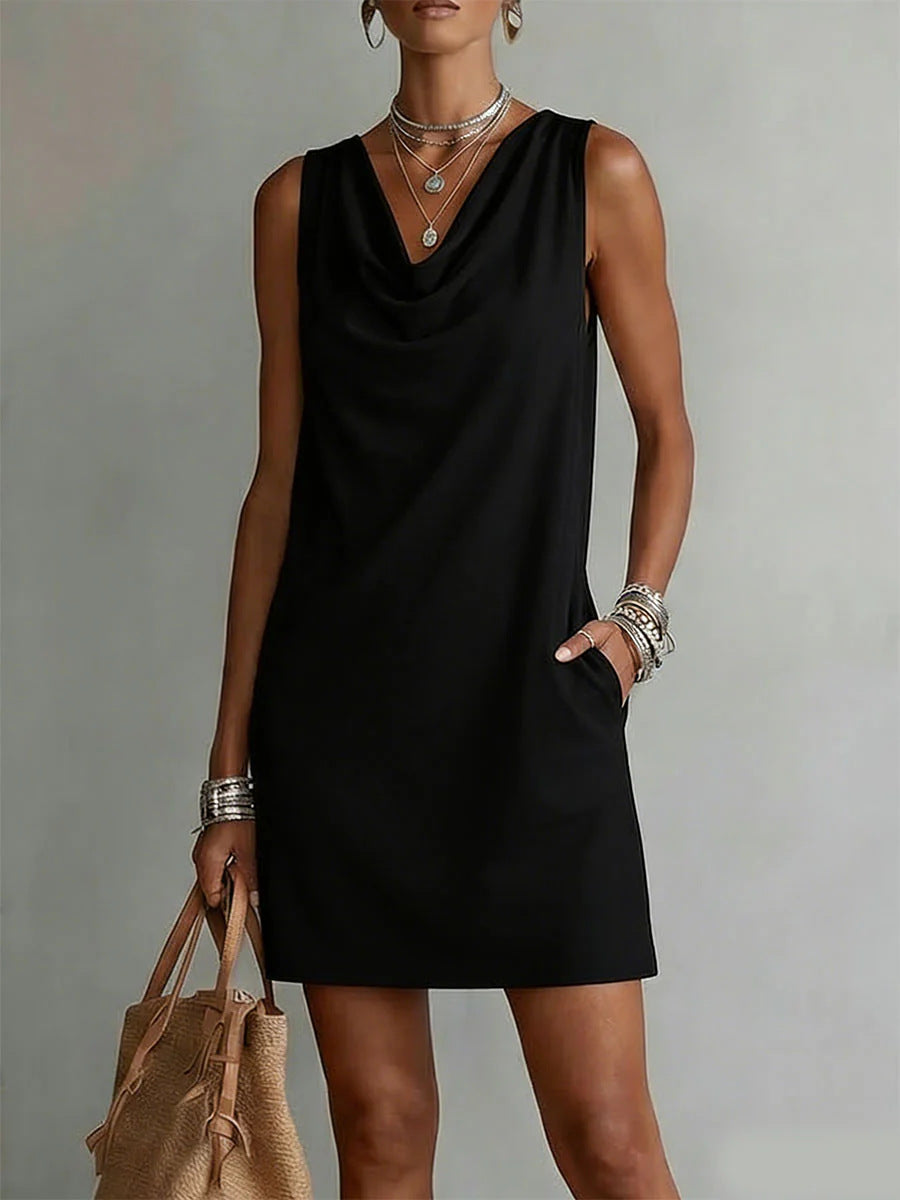 Woman wearing a black sleeveless dress with a plain background