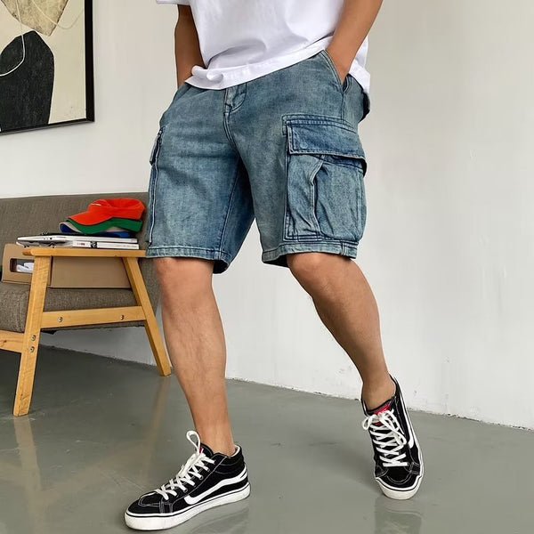 Person wearing blue cargo shorts and black sneakers in a room with a couch and colorful cushions.