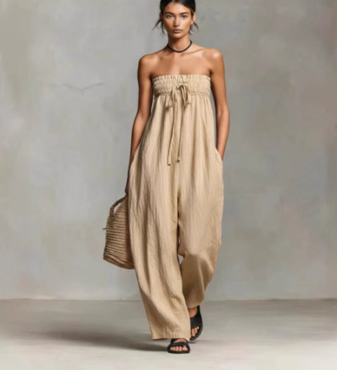 Woman wearing a beige strapless jumpsuit against a neutral background