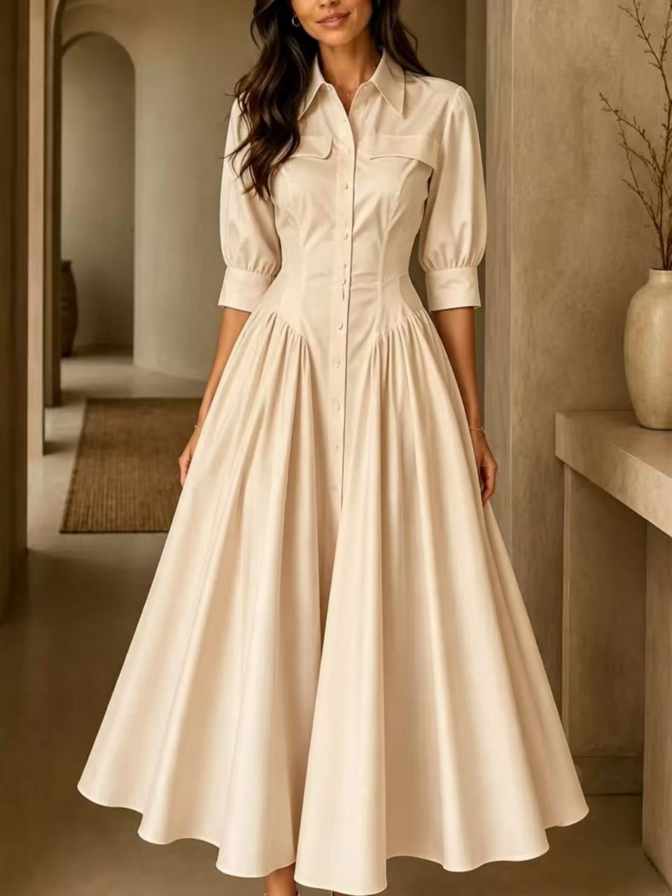 Woman wearing a long, light-colored dress in an indoor setting.