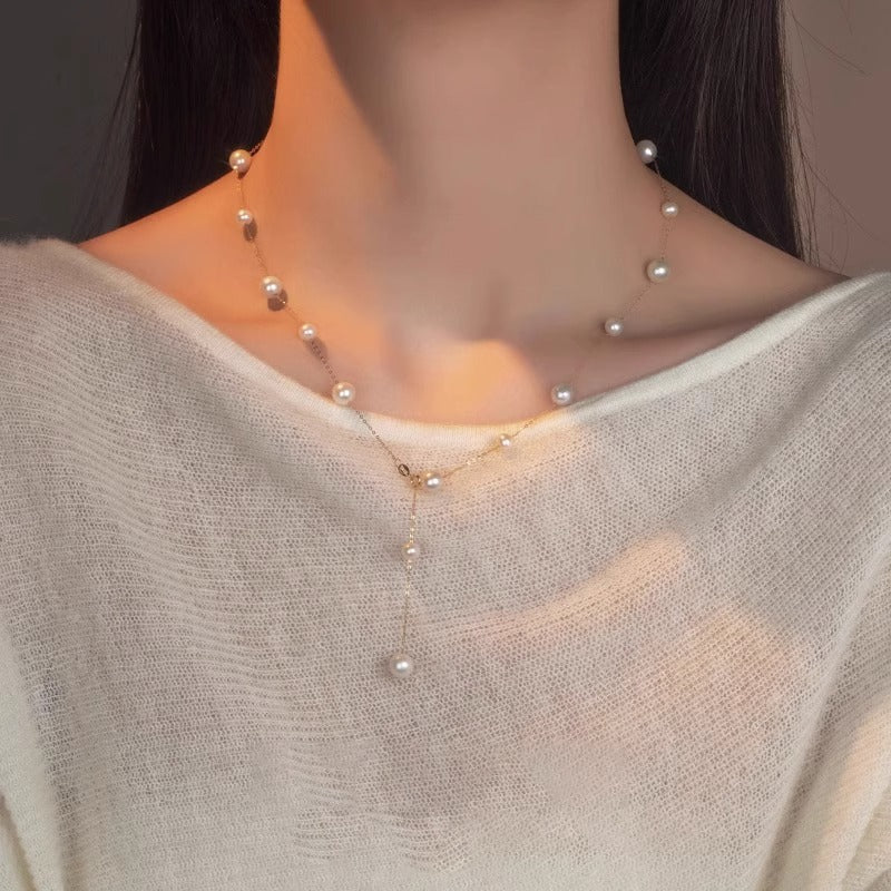 Pearl necklace worn by a person with a neutral background