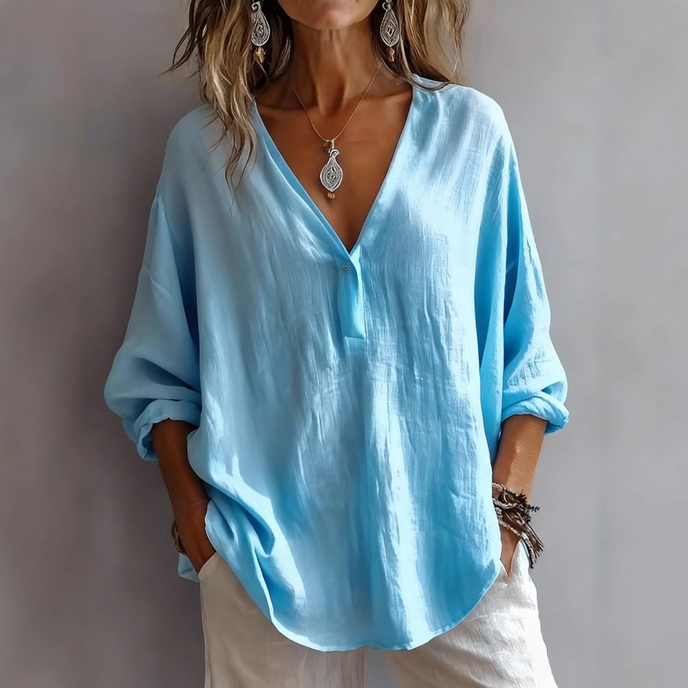 Woman wearing a light blue blouse with a plain background